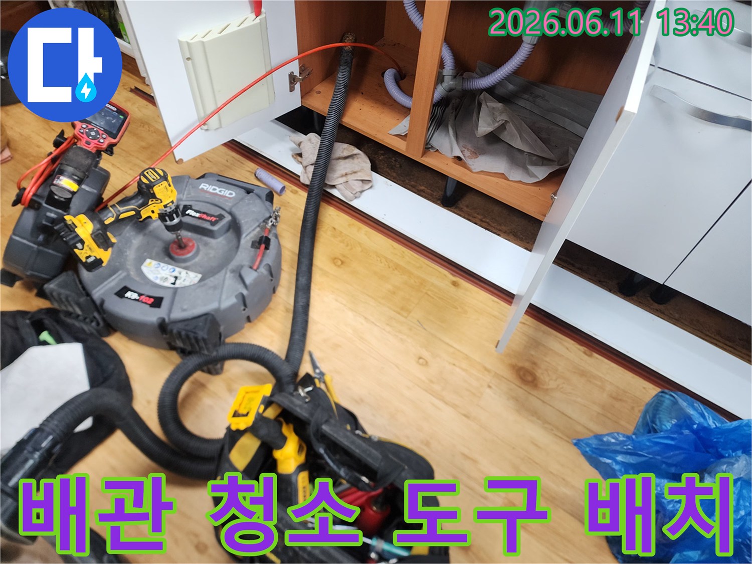 싱크대 배관 내부를 청소하기 위해 설치된 리지드 흡입 장비와 호스입니다.