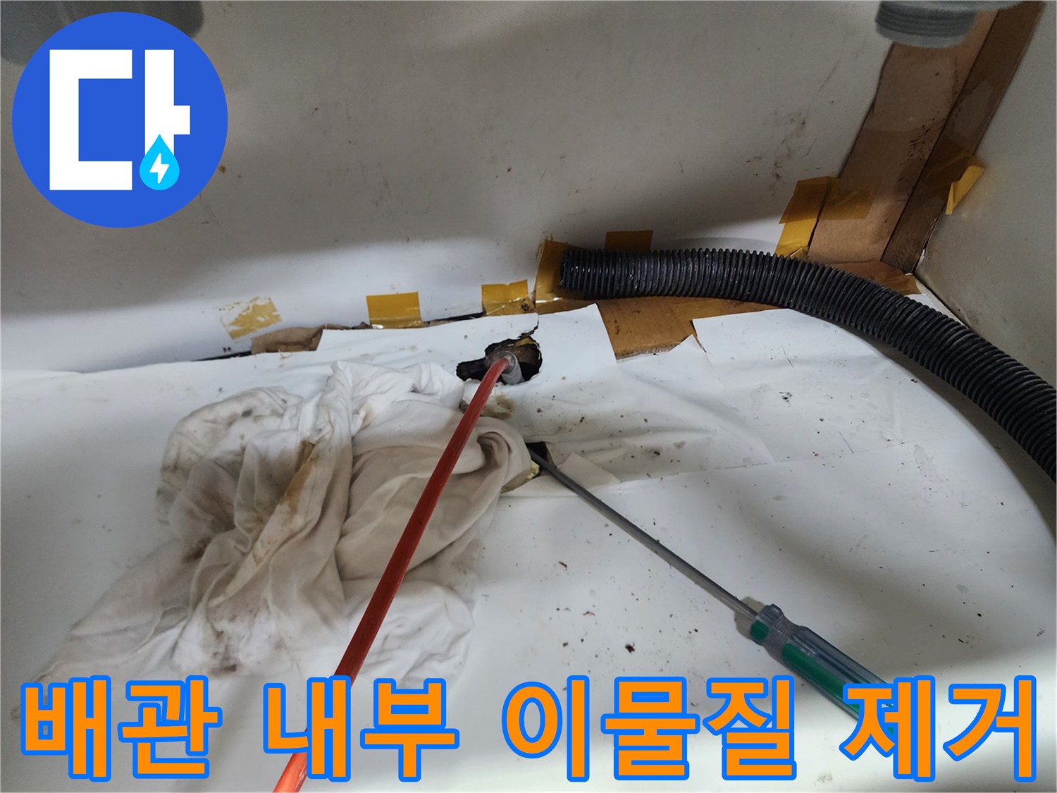 싱크대 하부장 바닥의 작업 도구와 오염된 배관 입구 모습