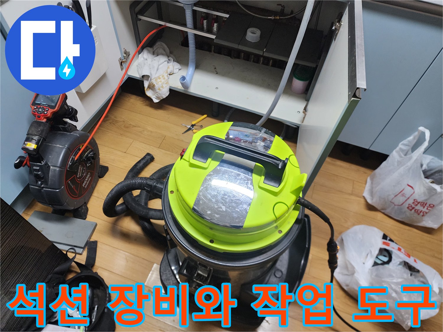 싱크대 하부장 내부에서 진행되는 석션 및 배관 청소 작업 모습