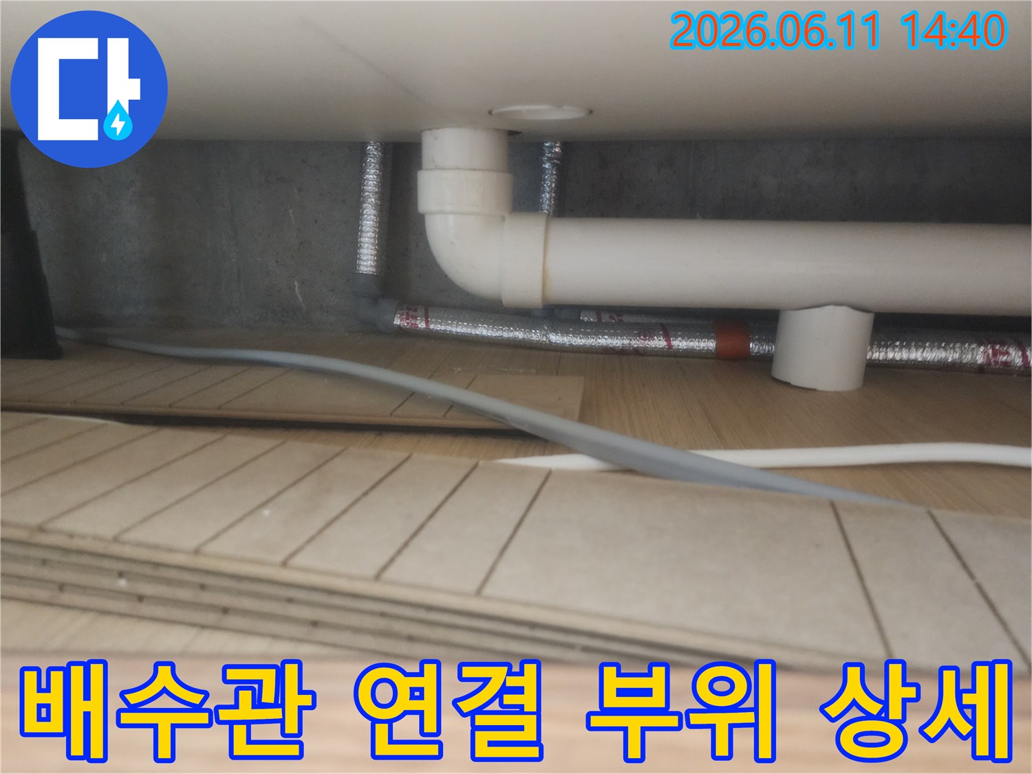 흰색 배수관과 은색 보온재가 연결된-배관 하부 모습
