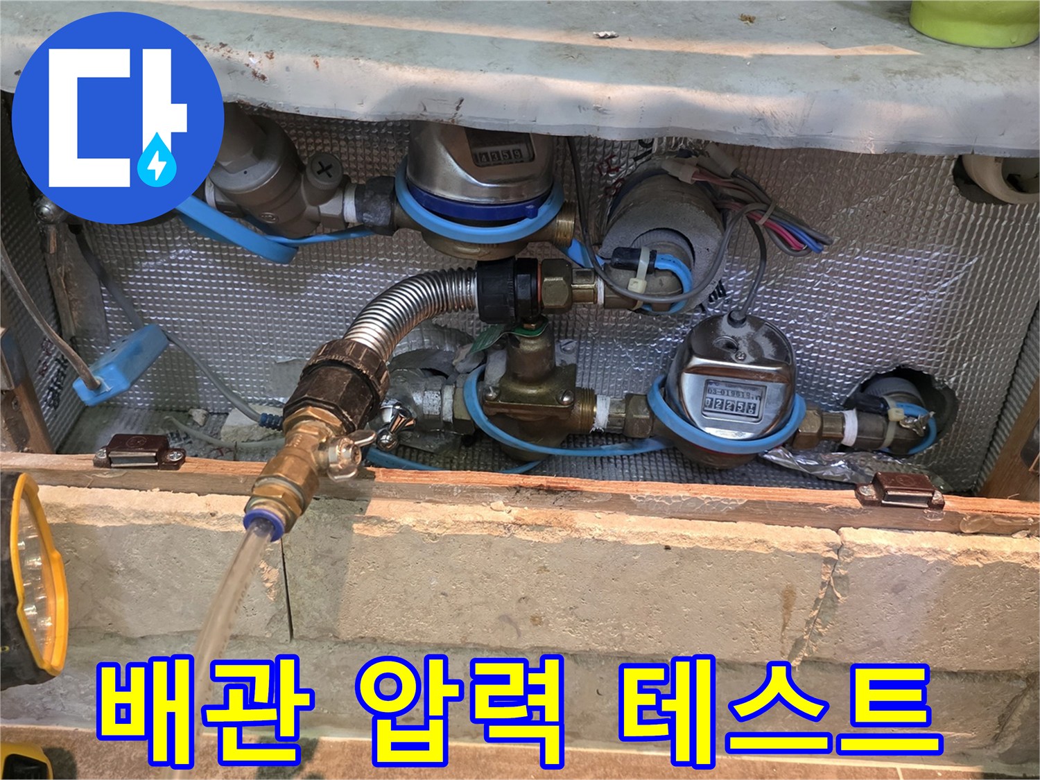 누수 진단을 위해 배관에 연결된 유연한 호스와 밸브-정확한 압력 테스트를 통해 누수 지점을 파악하는 과정입니다.