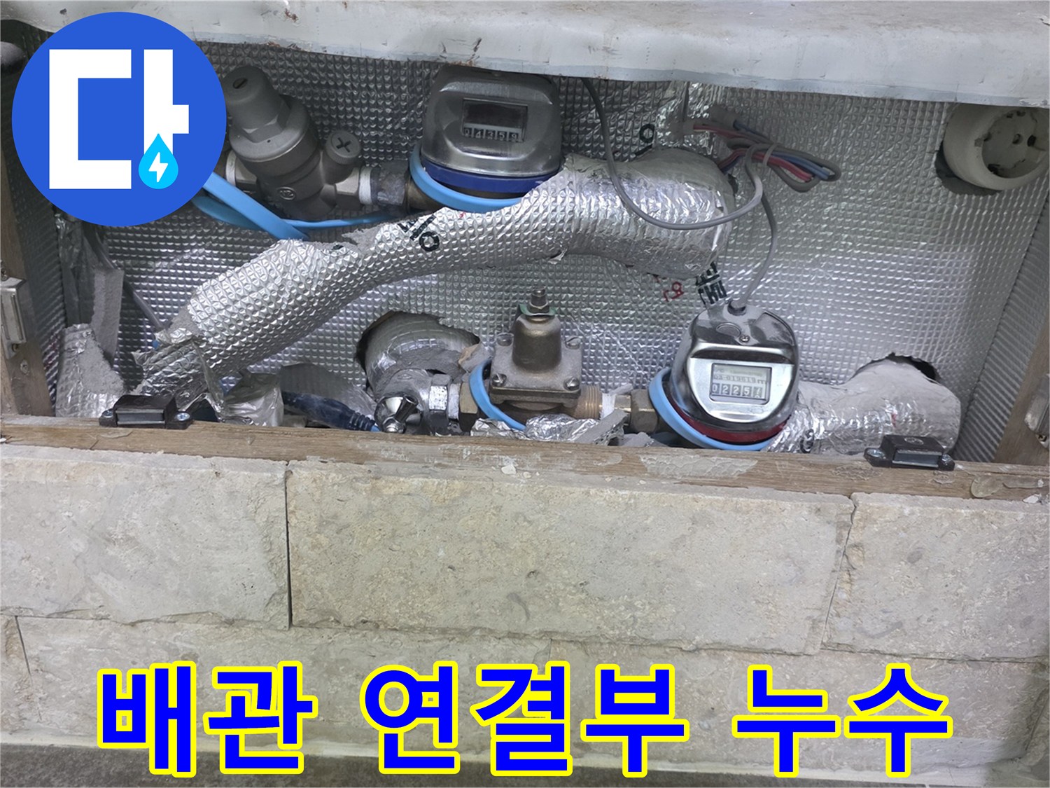 보온재로 감싸진 배관의-연결 부위와-수도 계량기가 보이는-누수 탐지 현장입니다