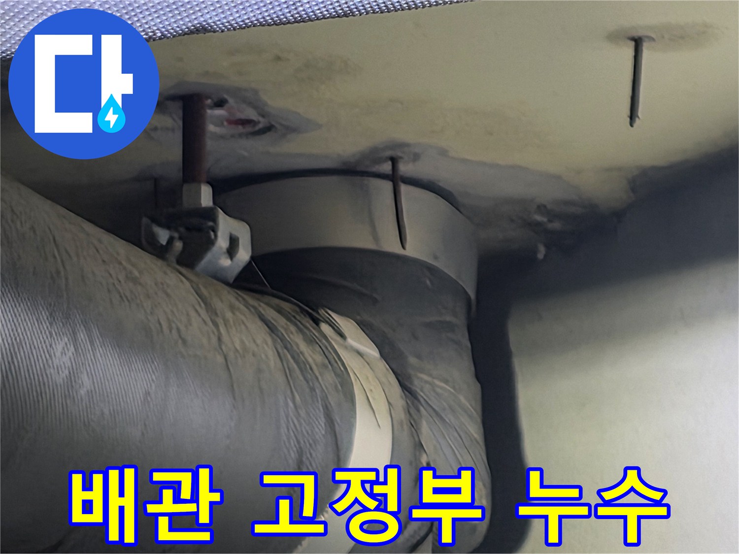 천장 배관 고정부 주변에 나타난 습기와 누수 흔적-이는 배관 연결부의 문제일 수 있습니다