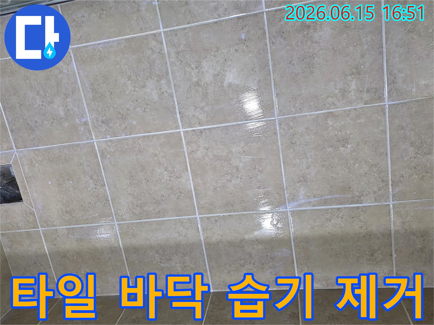 타일 바닥에 넓게 퍼진 습기는 누수가 진행되고 있음을 시사하며-전문적인 탐지가 필요한 상황입니다