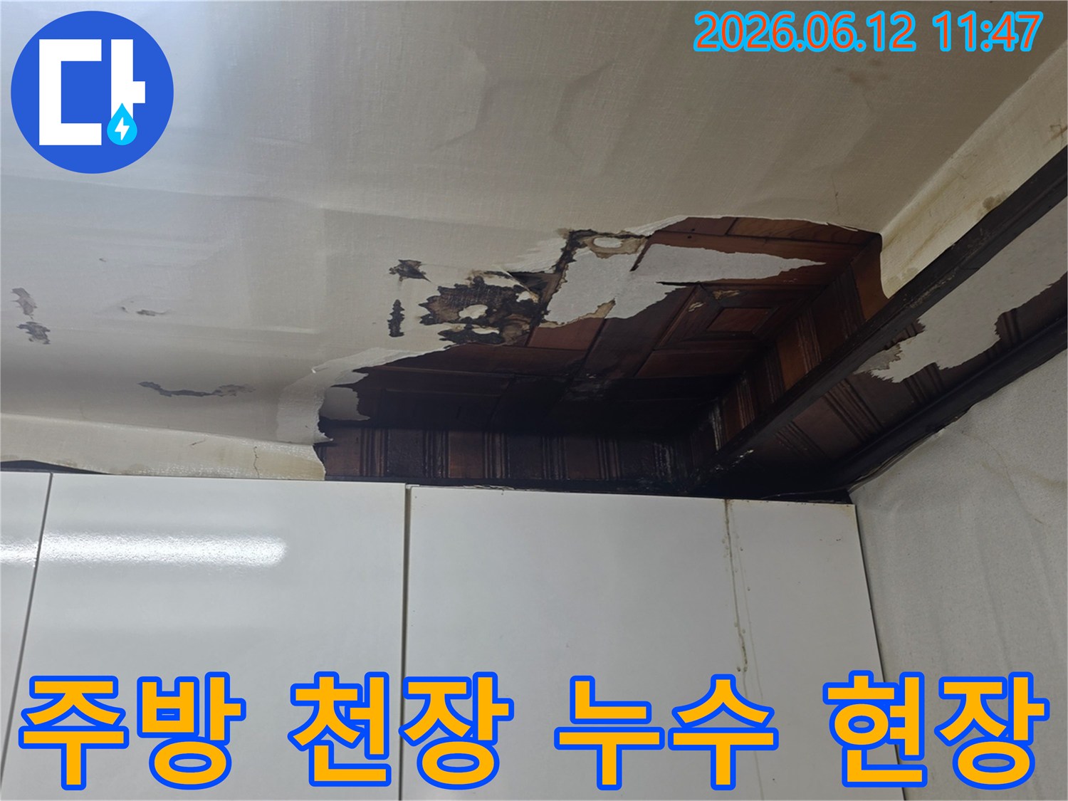 주방 싱크대 위 천장에서 물이 새어-벽지가 젖고 손상된 모습