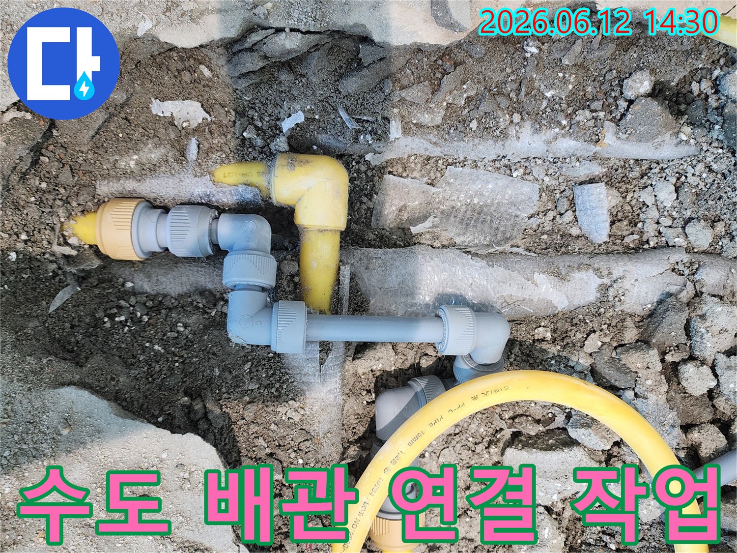 콘크리트 바닥 아래에 노출된 노란색 가스-배관과 회색 수도-배관이 복잡하게 연결된 누수-탐지 및 수리 현장입니다