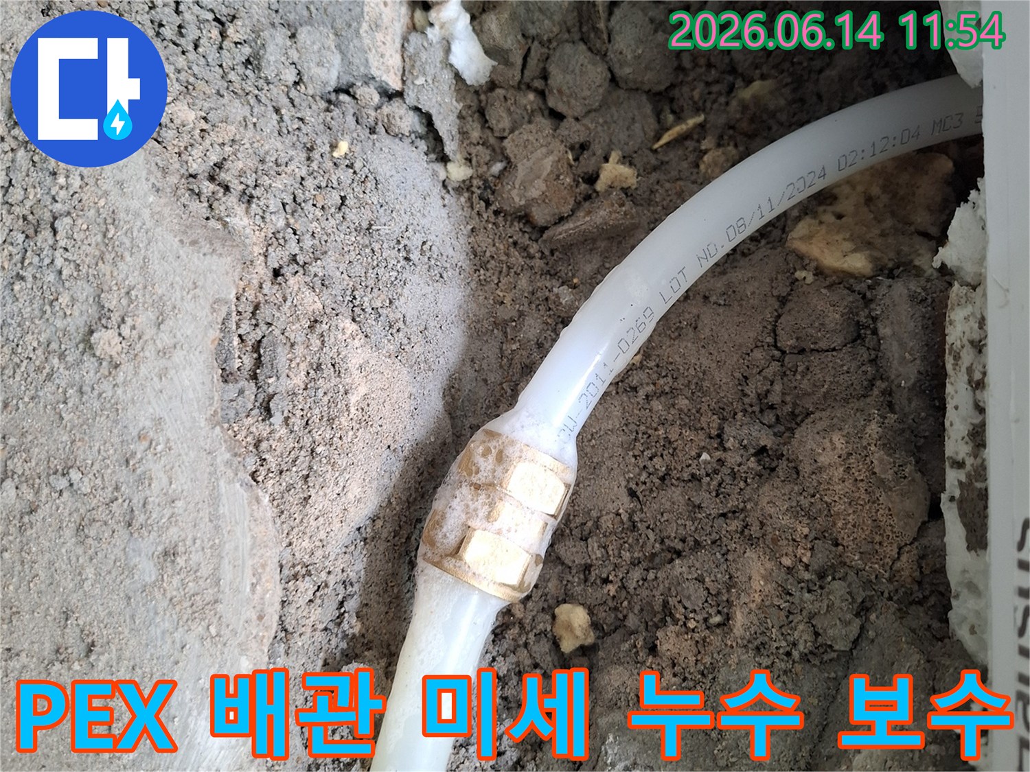 흙 속에 노출된-PEX 수도 배관의-연결 부위에서-미세 누수 흔적이-발견되어-정밀 보수 작업을-진행 중인-공사 현장 사진입니다