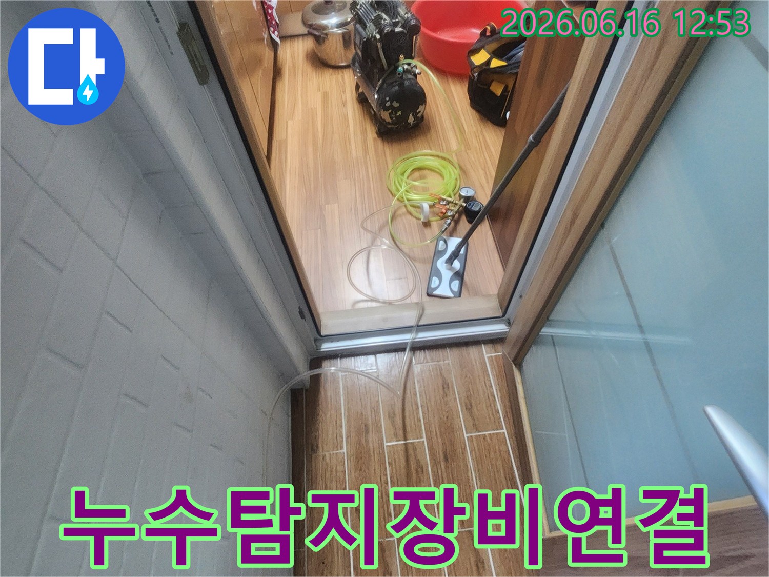 누수 엔지니어가 아파트 내부에서 누수-탐지 장비를 연결하며 작업 준비를 하고 있습니다.