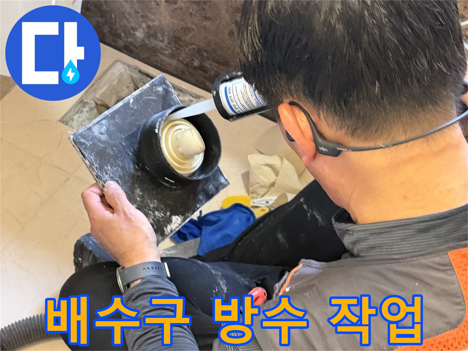 배수구 주변의 틈새를 메우기 위해 충전재를 사용하는 모습입니다.