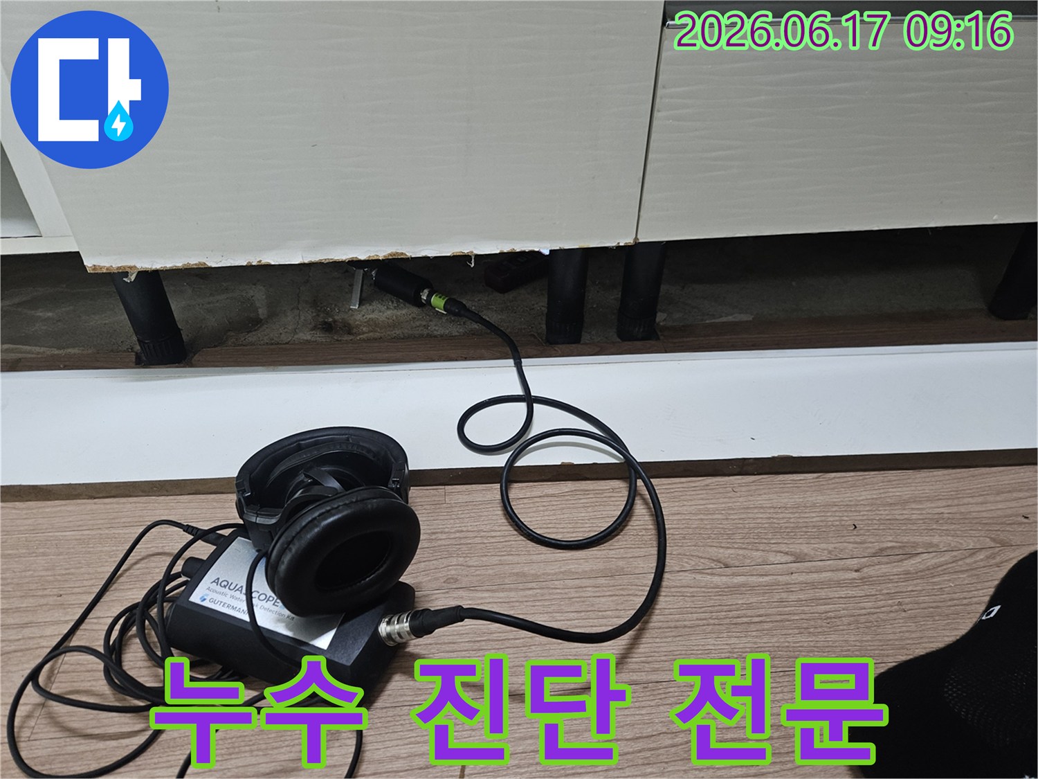 누수 탐지 엔지니어가-청음식 장비를 사용하여-싱크대 하부 배관의 누수 지점을 전문적으로 진단하는 모습