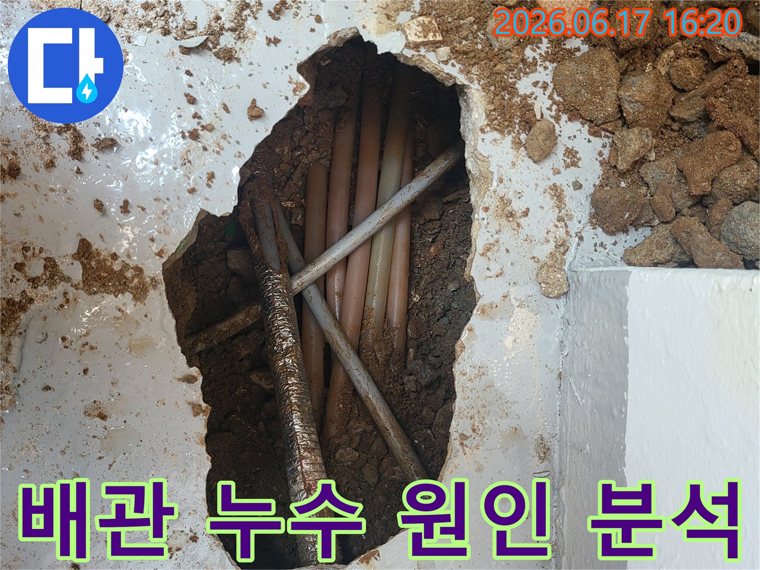 이 사진은 누수 지점을 확인하기 위해-콘크리트 바닥을 깨고 매설된 배관들을 점검하는-누수 공사 현장의 모습입니다.