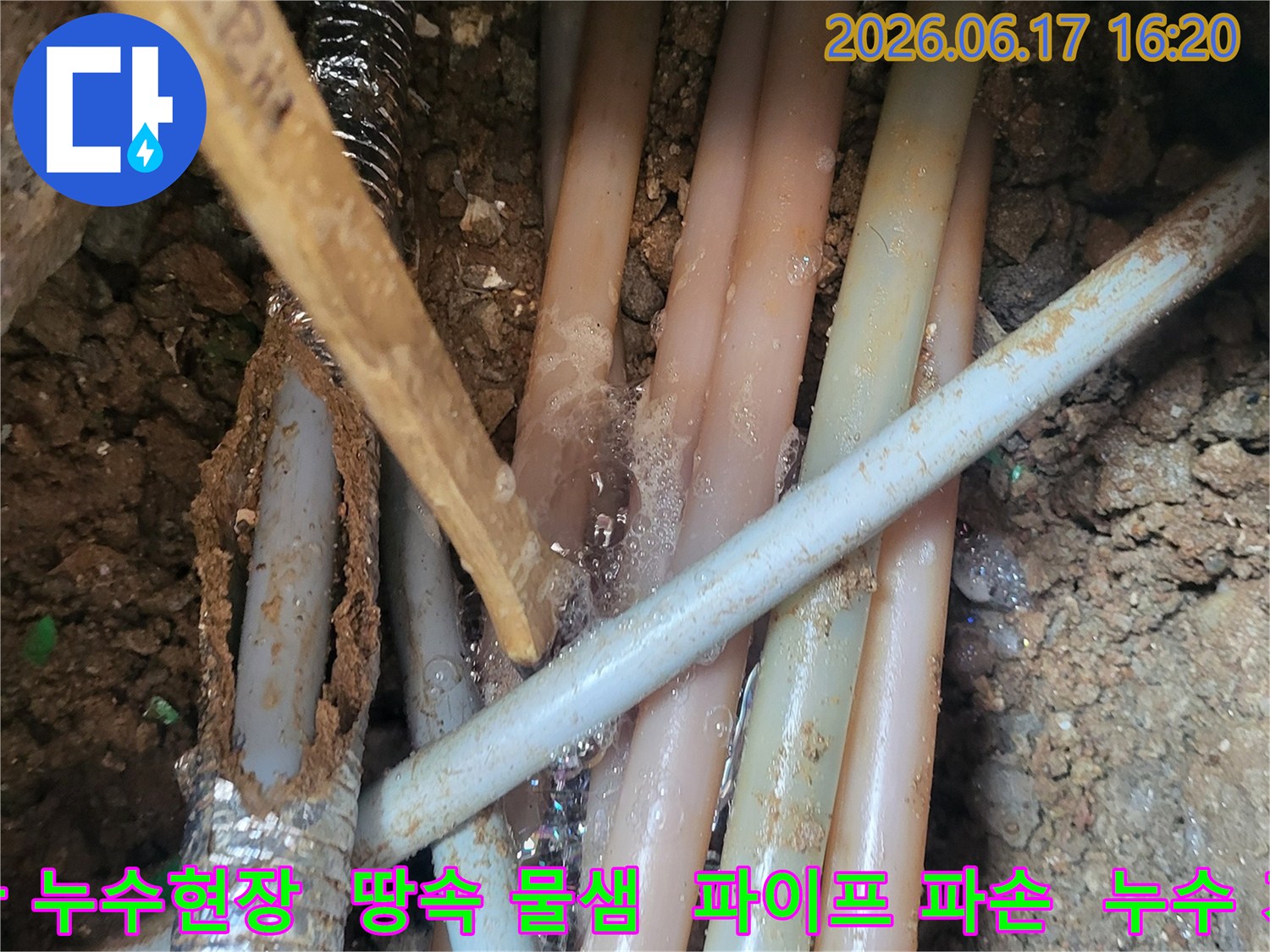이 이미지는-땅속에 묻힌-여러 배관들 사이에서-물이 새어 나오는-누수 현장을-보여줍니다-특히-거품이 발생하는-지점이-누수의-정확한 위치를-확인시켜주고-있습니다