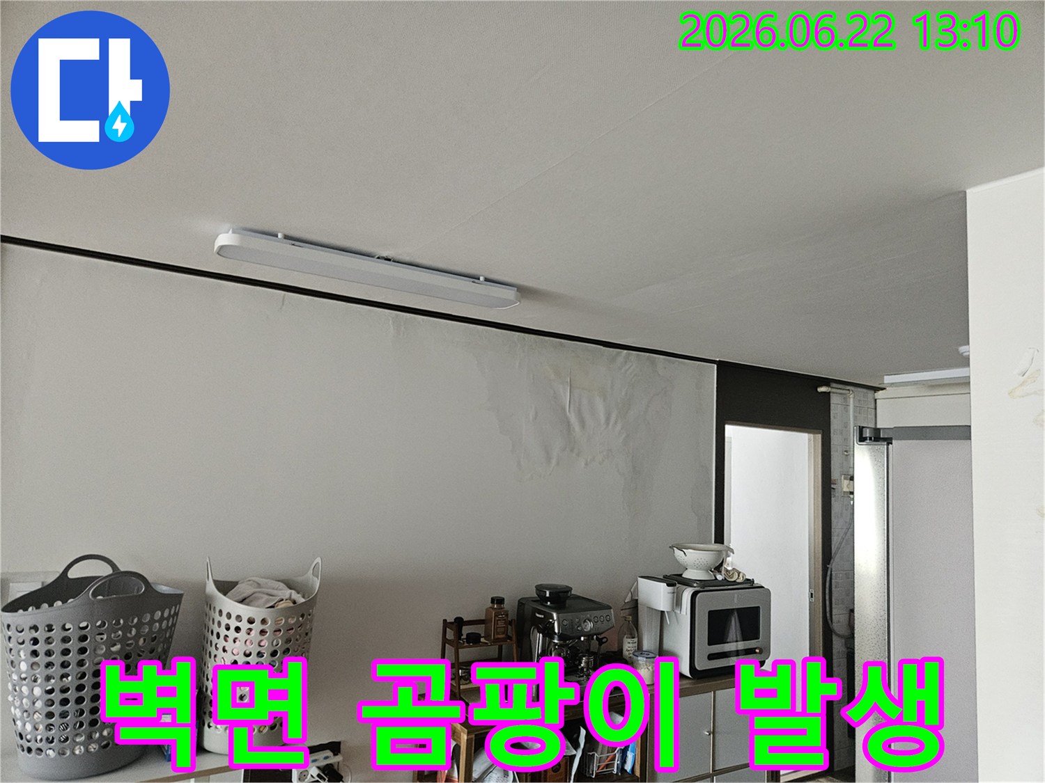 물에 젖어 얼룩지고 손상된 벽면과-그 위로 보이는 천장의 모습에서 누수의 심각성을 짐작할 수 있는 사진입니다.