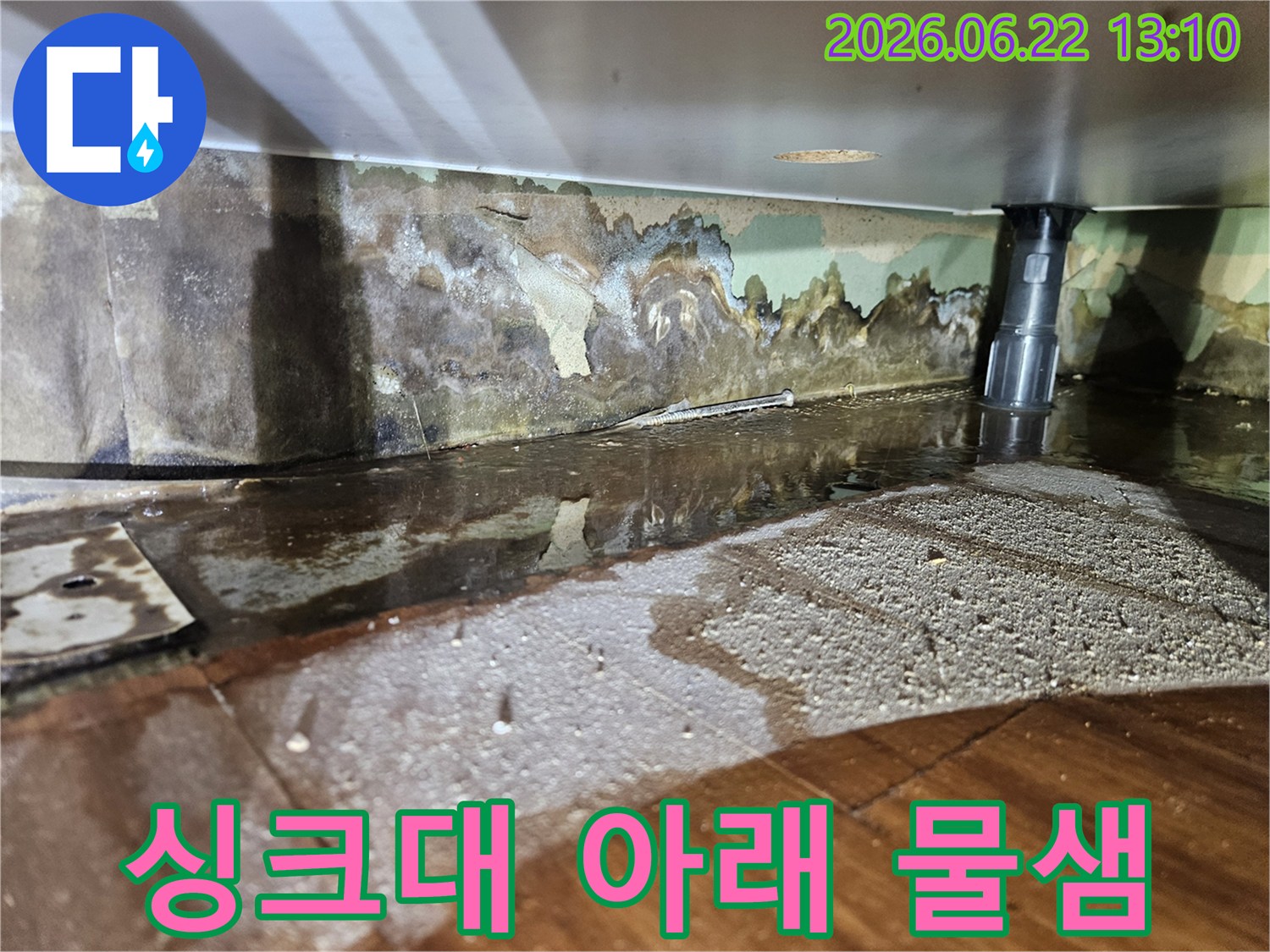 싱크대 아래에서-물이 새어 나와-벽면과 바닥이 젖고-벽지가 손상된-누수 현장-사진