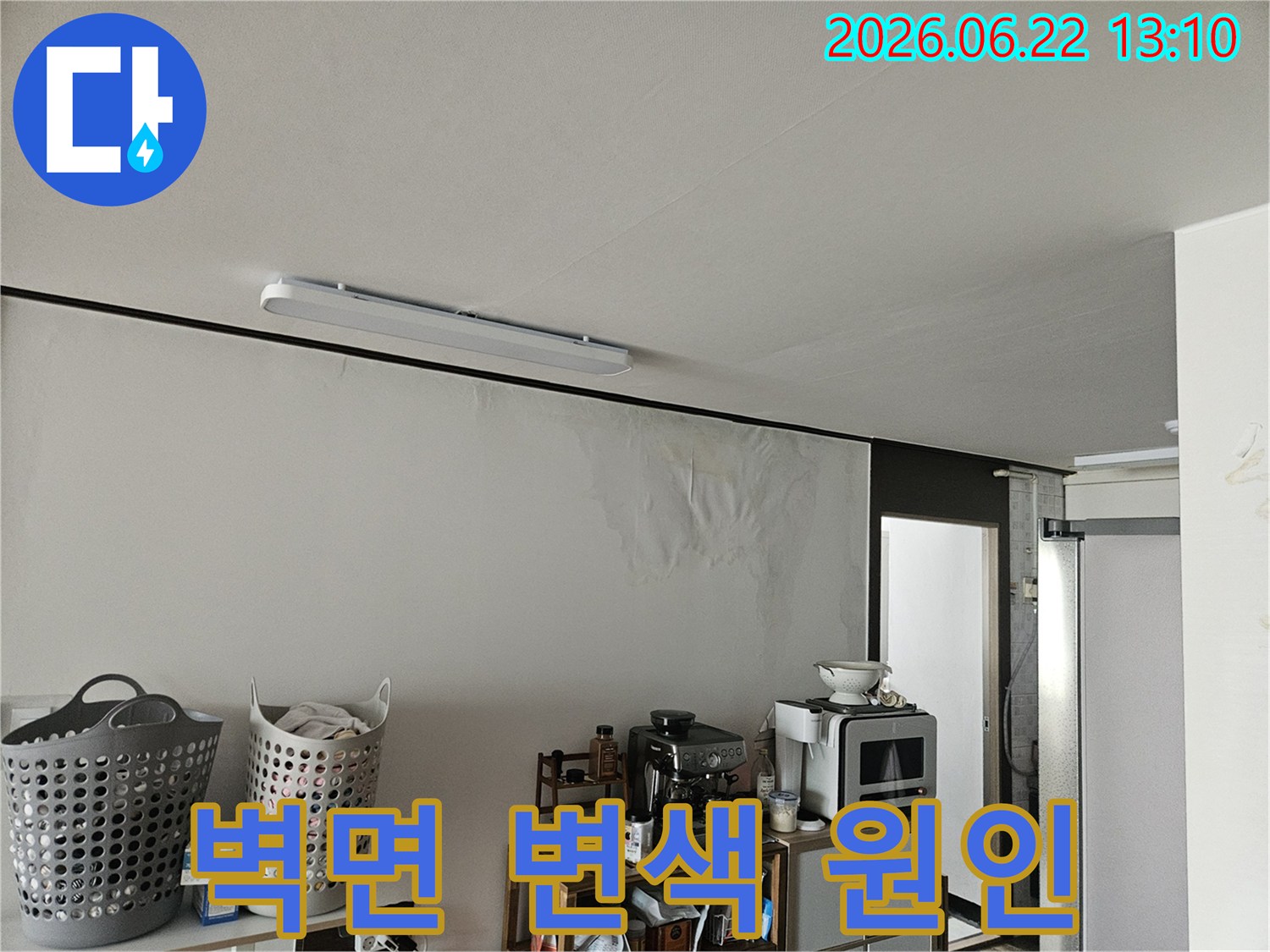 윗집 배관 문제로 추정되는 누수 현상으로-벽면이 물에 젖어 변색되고 손상된 주택의 한 부분을 촬영한 사진입니다.