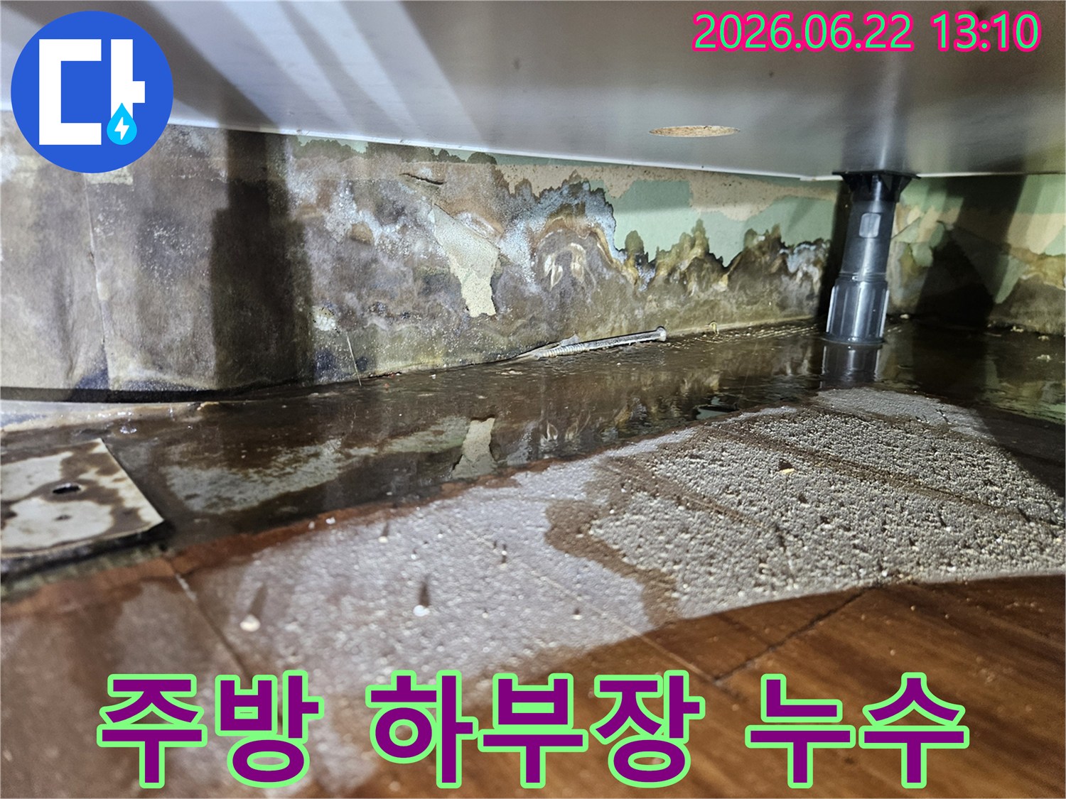 주방 하부장 아래에서-물이 새어 나와-벽면과 바닥이 젖고-벽지가 손상된-누수 현장-사진