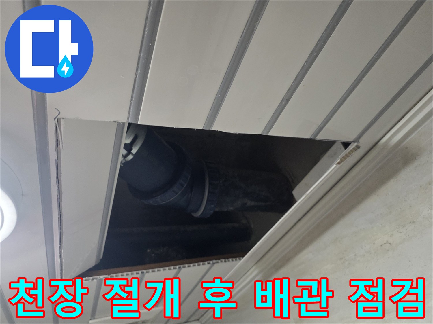천장 판넬 사이를 통해 내부의 어두운 배관 구조물을 촬영한 사진