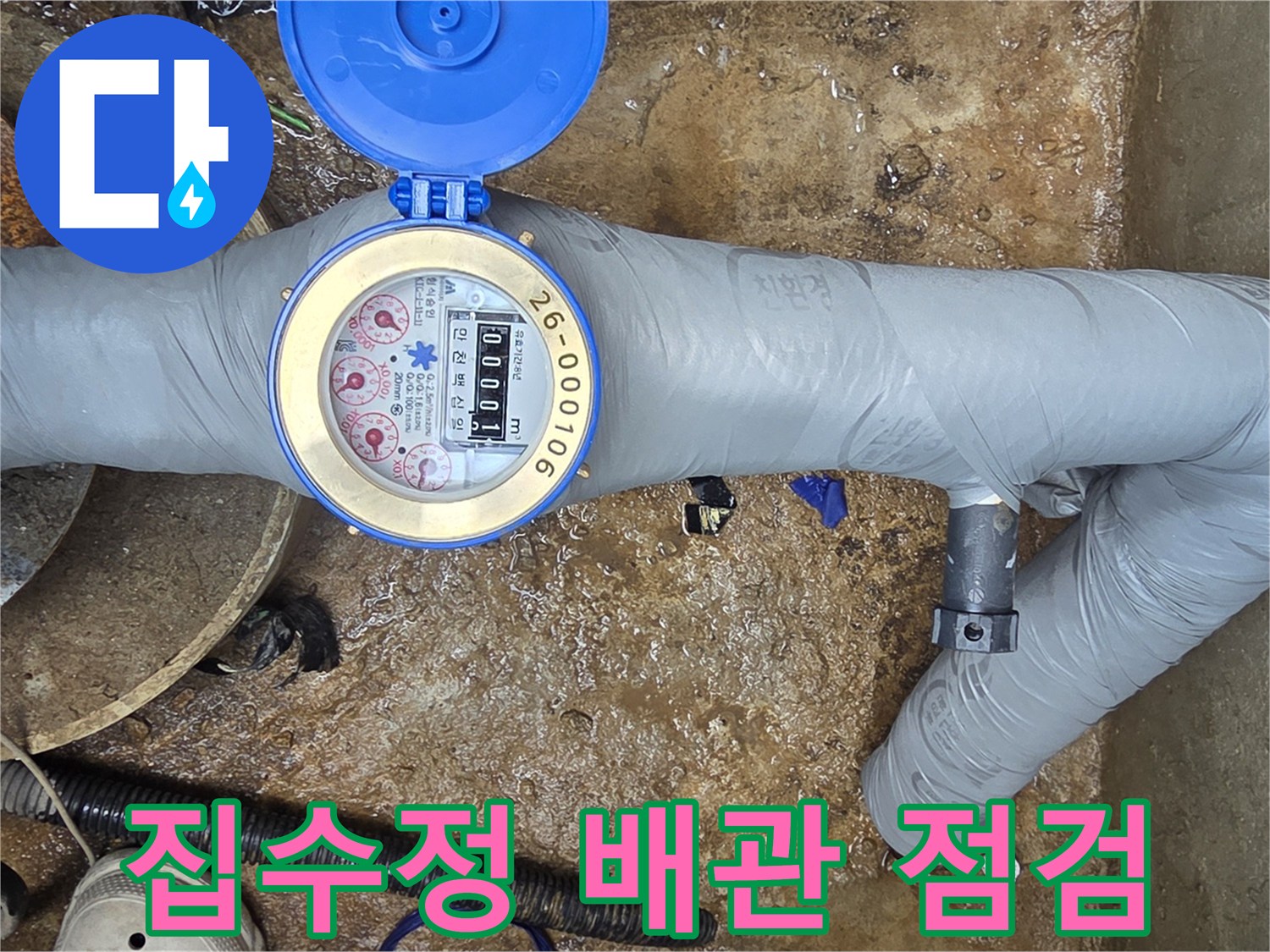회색 보온재로 덮인 지하수 배관과 계량기 수치 확인