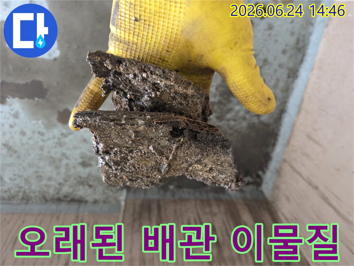 누수-탐지-작업-중-발견된-배관-내부의-심각하게-부식된-파편을-작업자가-확인하고-있는-사진입니다.