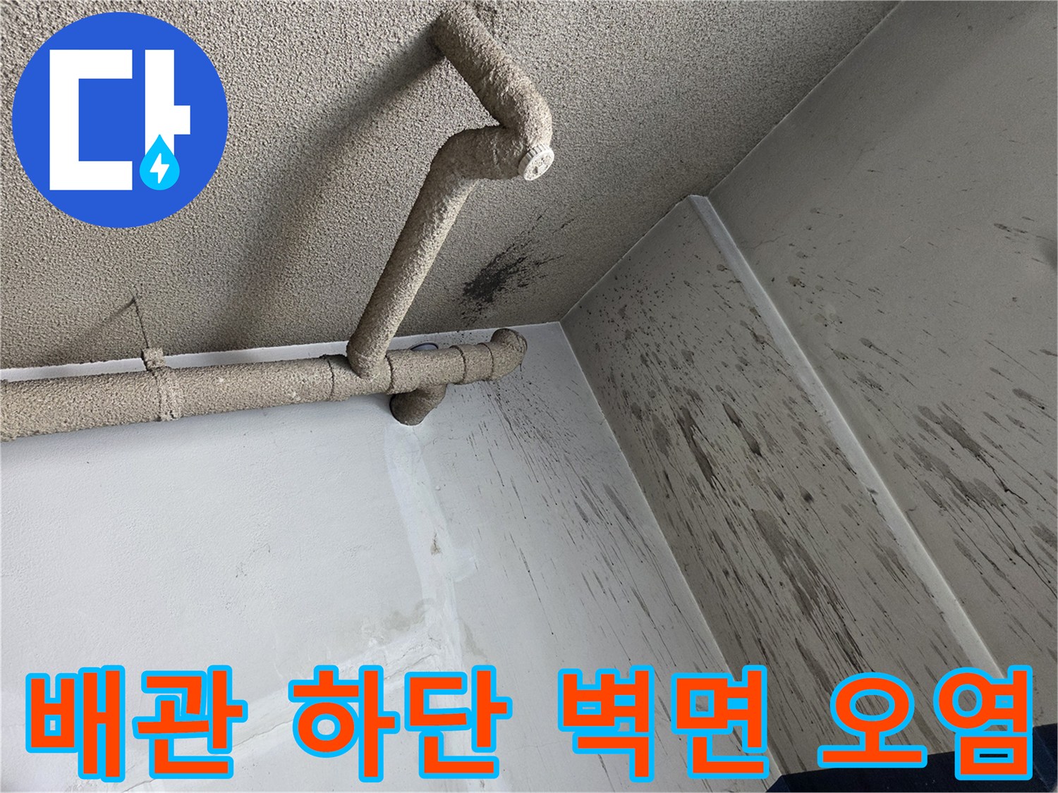 천장 배관 아래쪽 벽면에 남은 검은색 오염 흔적을 촬영한 사진입니다.