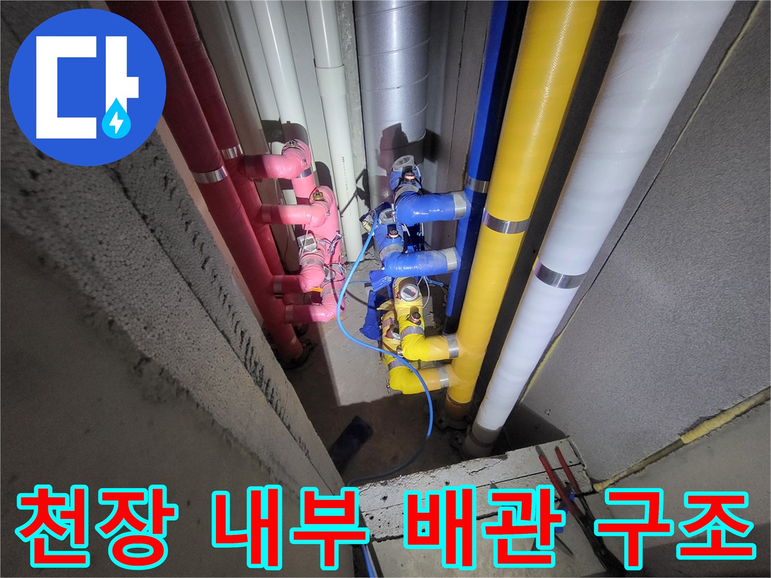 다양한 색상의 배관이 수직으로 배열된 천장 점검 구간