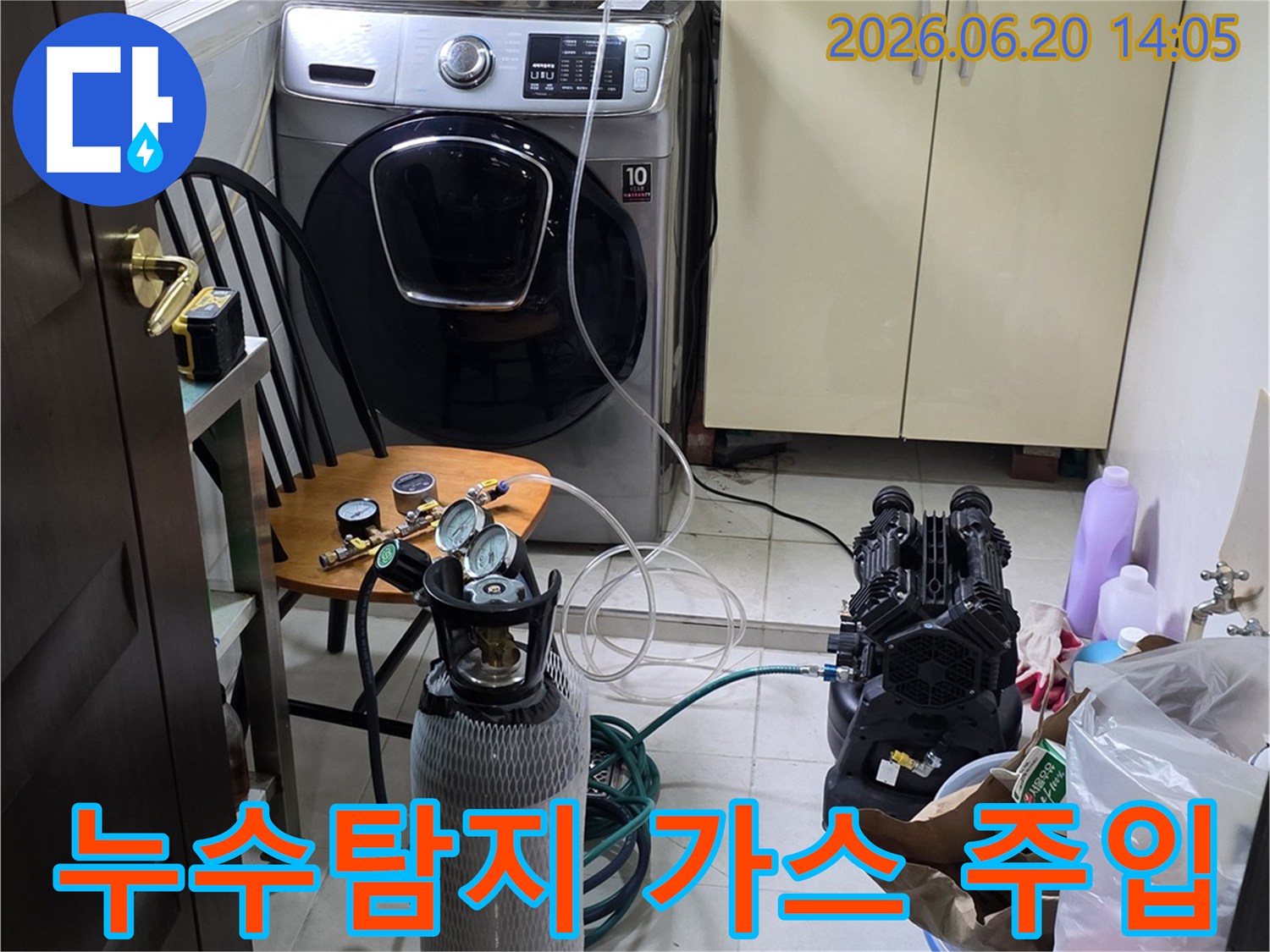 세탁실에서 누수 탐지용-질소 가스 장비를 연결하여-압력 테스트를 준비하는 장면