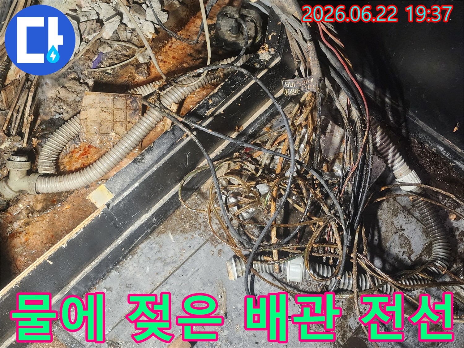 누수-엔지니어가-물에-젖어-부식된-배관과-전선이-복잡하게-얽혀있는-현장을-꼼꼼히-점검하고-있습니다