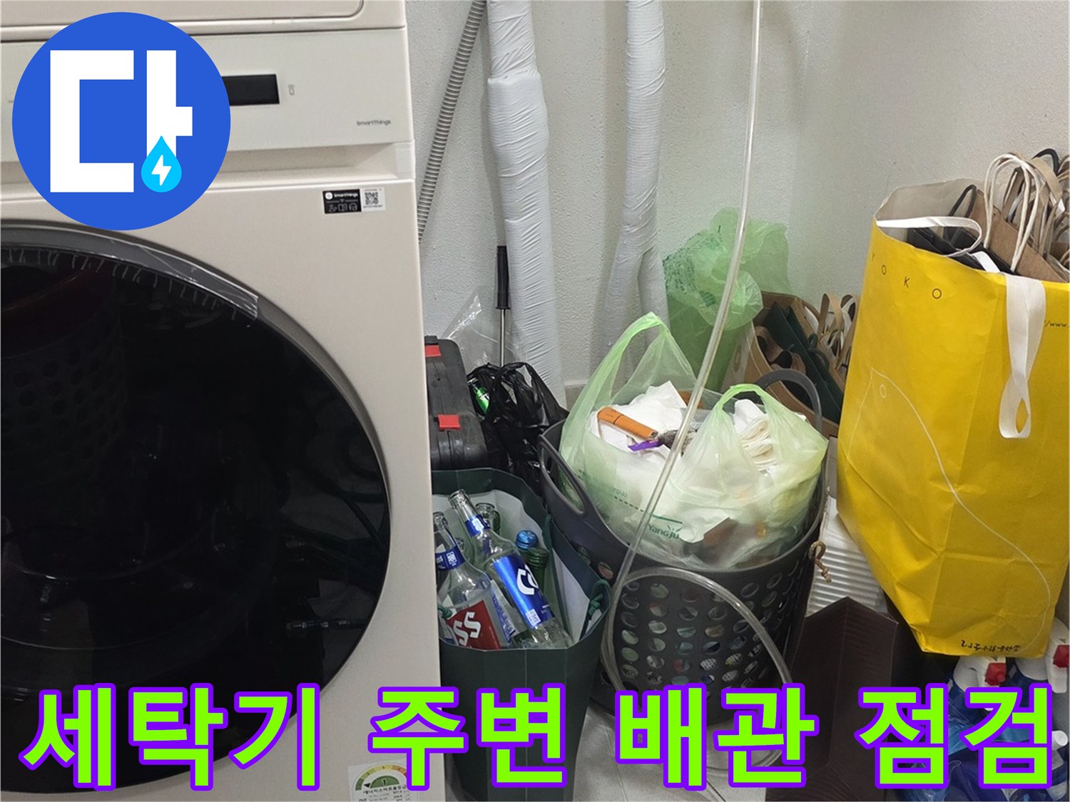 세탁기와 하부장 근처의 노출된 배관 및 점검 장비 모습