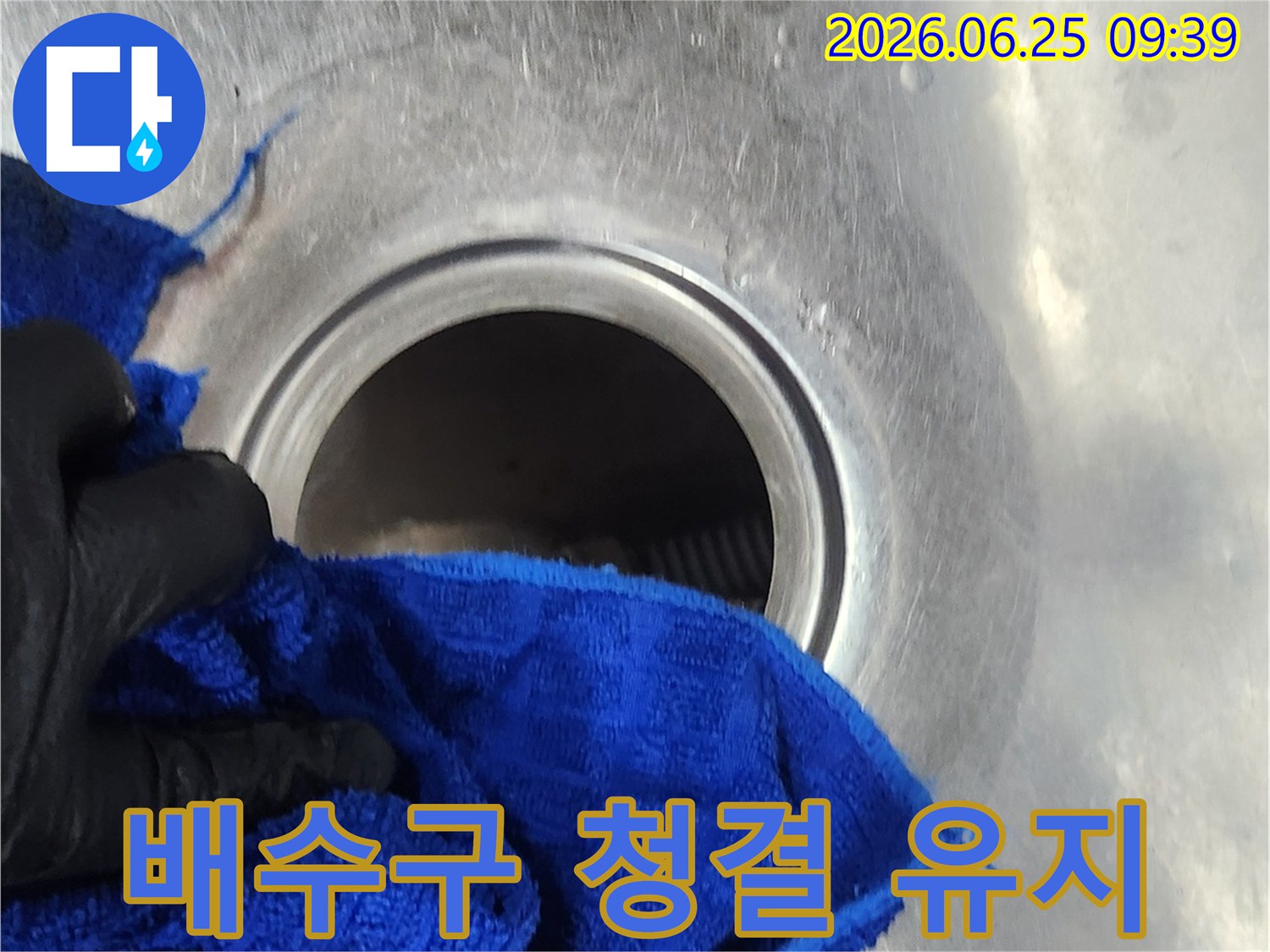 작업자가-새로운-배수통-설치-전-배수구-주변을-청결하게-유지하는-모습입니다