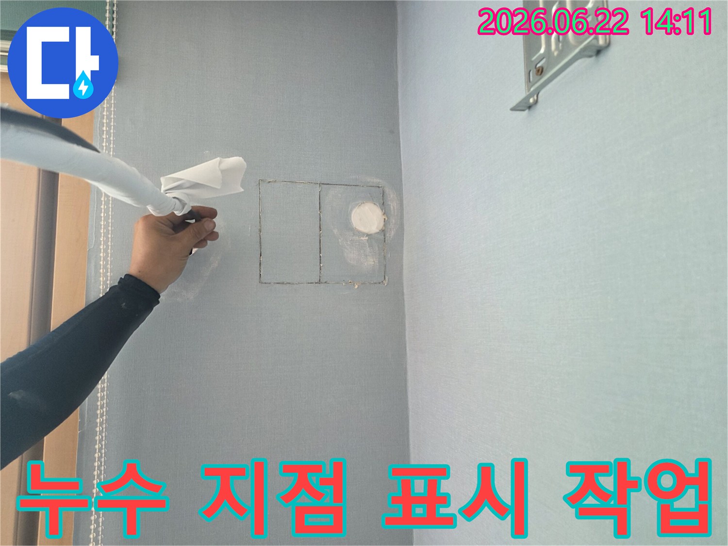 누수 탐지 전문가가-정확한 수리를 위해-벽면에 누수 지점을 표시하고 있습니다.