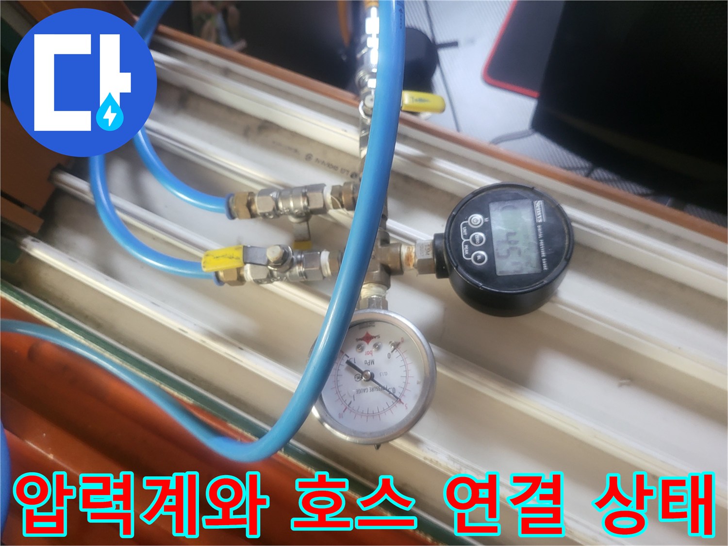 배관에 연결된 파란색 호스와 수치를 나타내는 압력 게이지