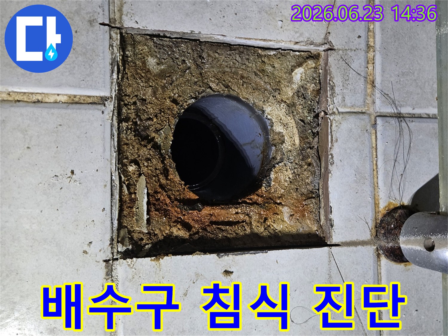 바닥 배수구 주변이 누수로 인해 심하게 침식되고-타일이 손상된 모습을 보여주는 현장 사진