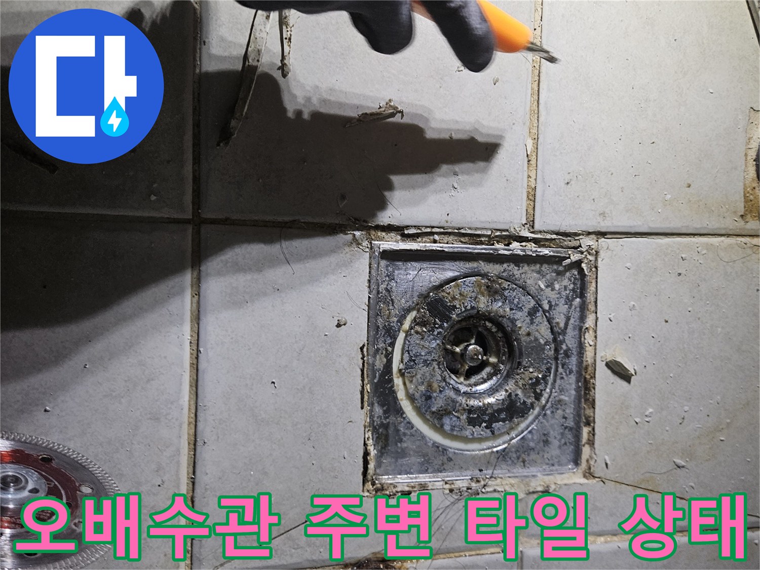 욕실 바닥의-배관 주위 타일 틈새와 오염된 부위를 촬영한 사진입니다.