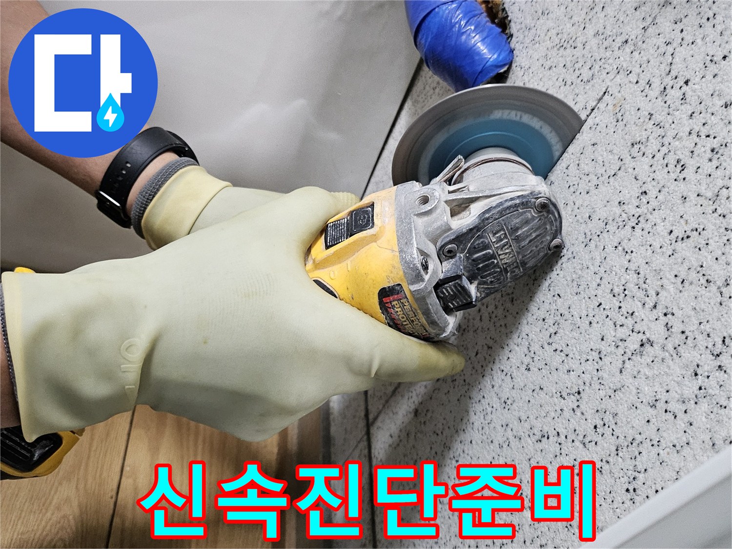 안전 장갑을 착용한 작업자가-그라인더로 천장 타일을-조심스럽게 절단하고 있습니다.