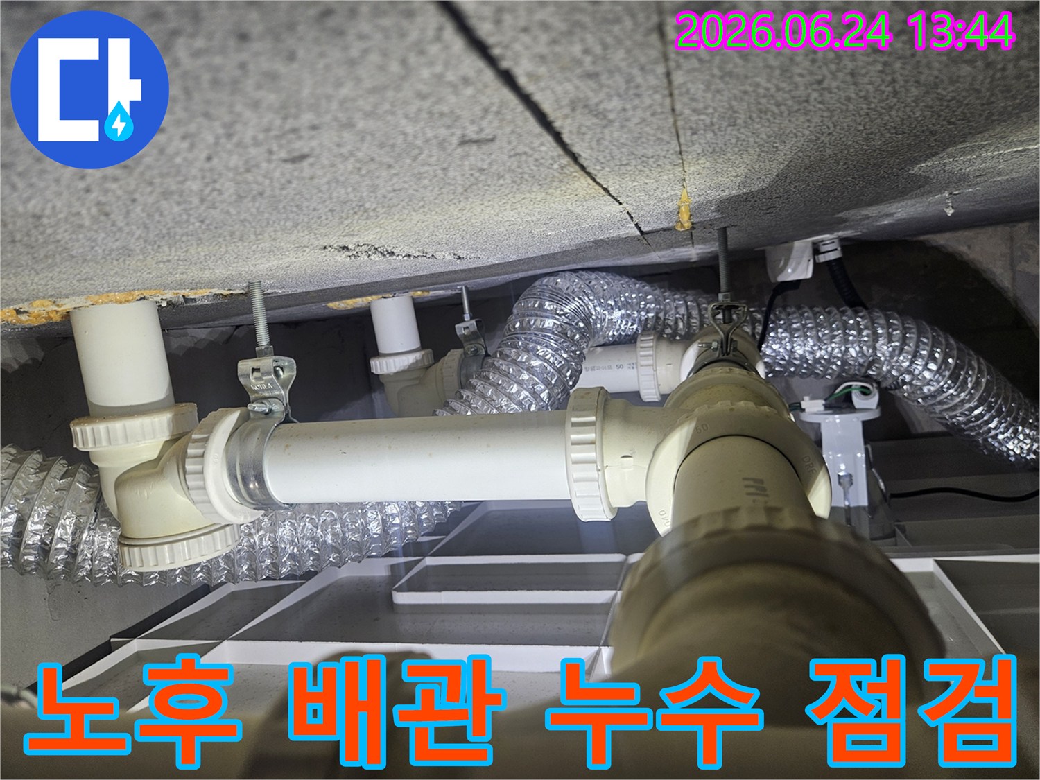 천장 아래 설치된-오래된 배관과-환기 덕트가-누수 여부를 확인하기 위해-정밀하게 검사되고 있습니다