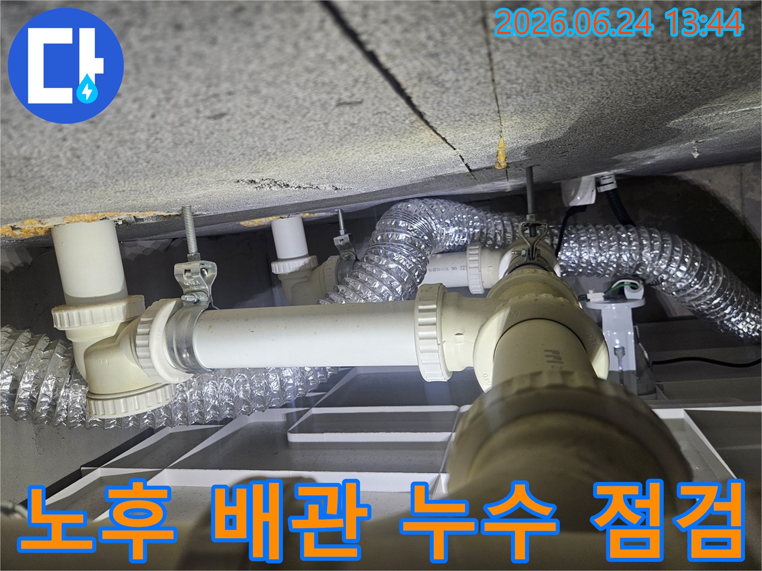 천장 아래 설치된-오래된 배관과-환기 덕트가-누수 여부를 확인하기 위해-정밀하게 검사되고 있습니다