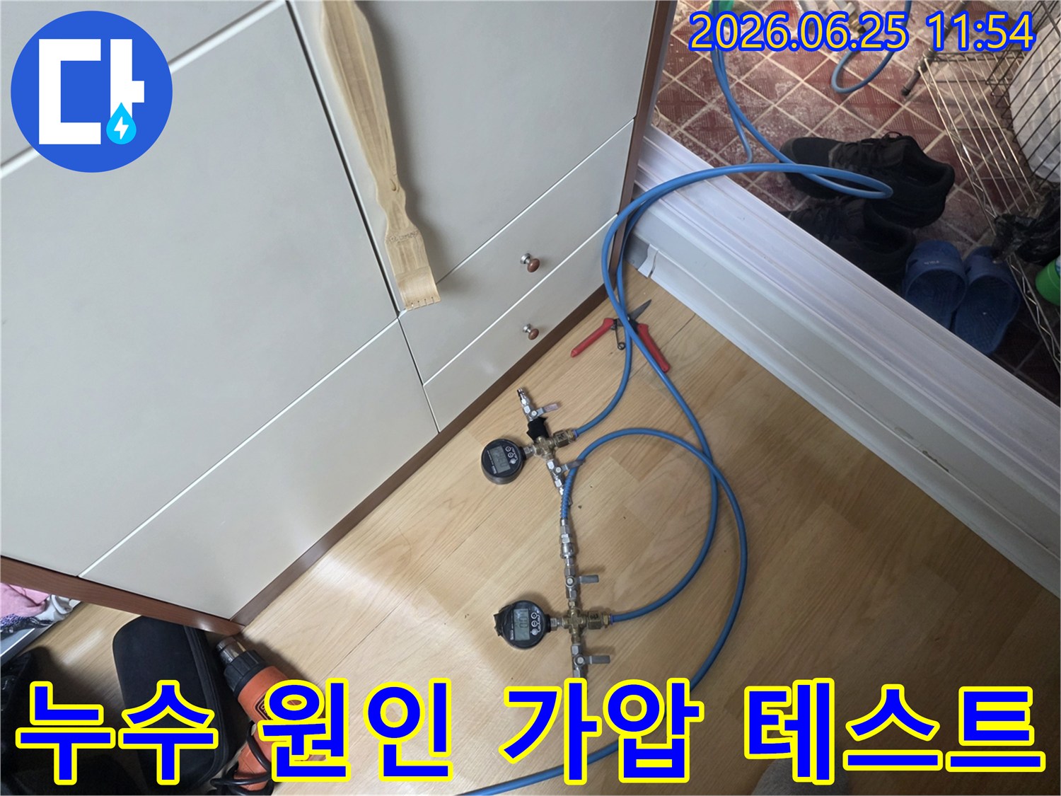 누수 엔지니어가 배관의 압력 변화를 감지하여 누수 여부를 확인하기 위해 디지털 게이지가 연결된 가압 테스트 장치를 설치하고 있습니다