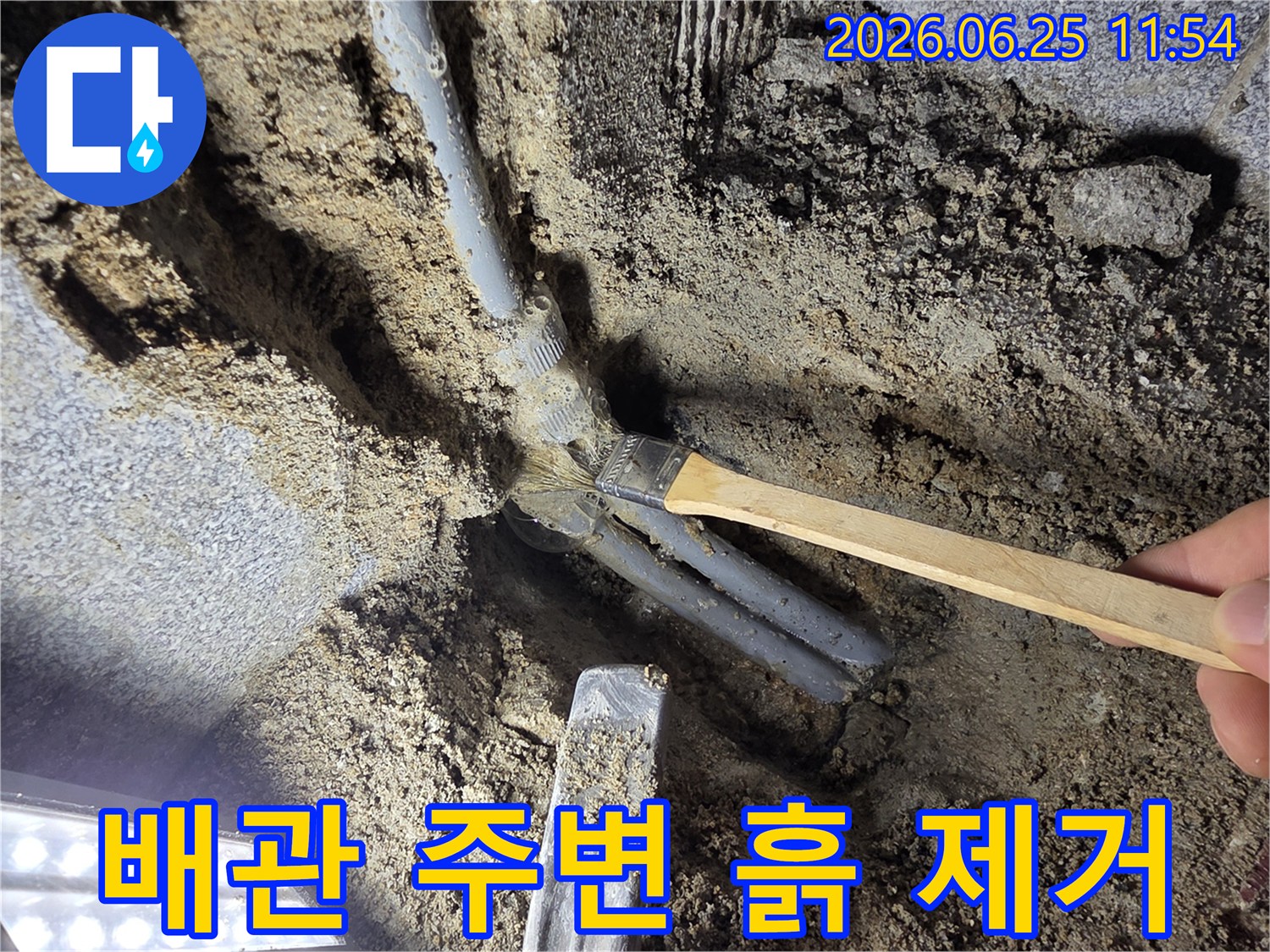 누수 탐지 전문가가 배관 주변 흙을 조심스럽게 제거하며 누수 원인을 파악하는 중요한 과정입니다