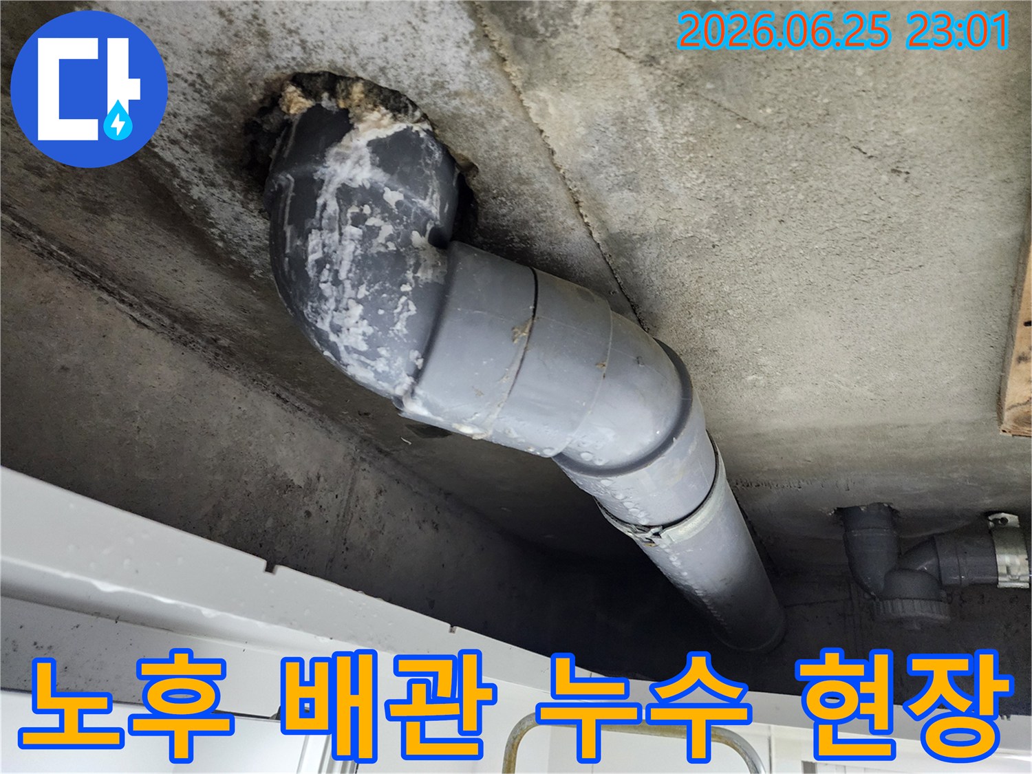 오래된 천장 배관에서-누수가 발생하여-주변 콘크리트가 젖고-하얀 침전물이 생긴-모습을 보여주고 있습니다