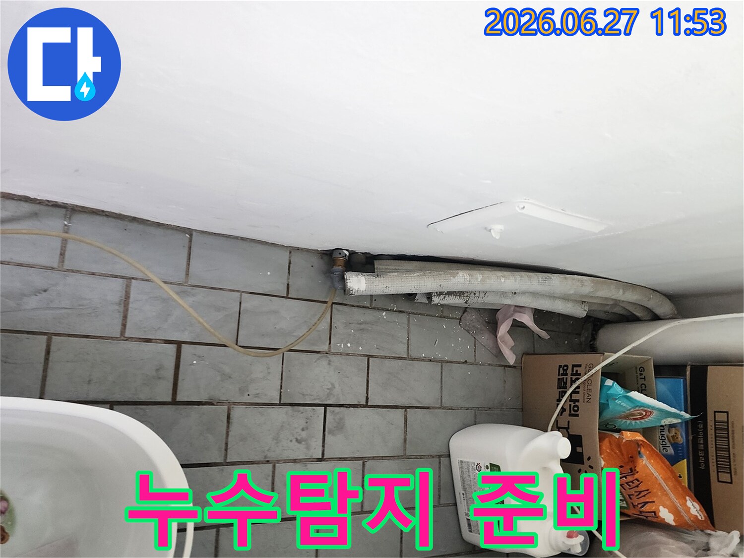 서울 도봉구 우성1차아파트의 다용도실에서-누수 원인을 찾기 위해-전문 탐지 장비를 준비하고-배관 주변을 확인하는 모습입니다.