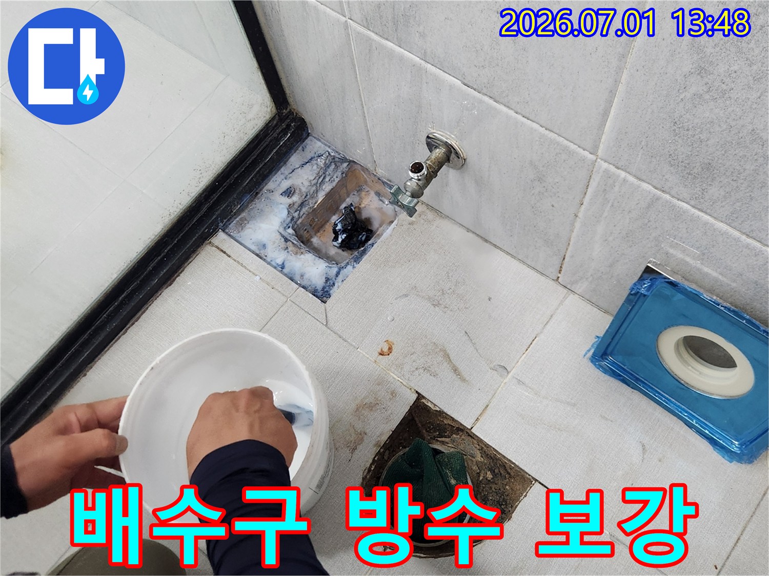 주택-욕실의-배수구-주변에서-발생한-누수를-막기-위해-타일을-제거하고-방수-재료를-혼합하는-모습입니다