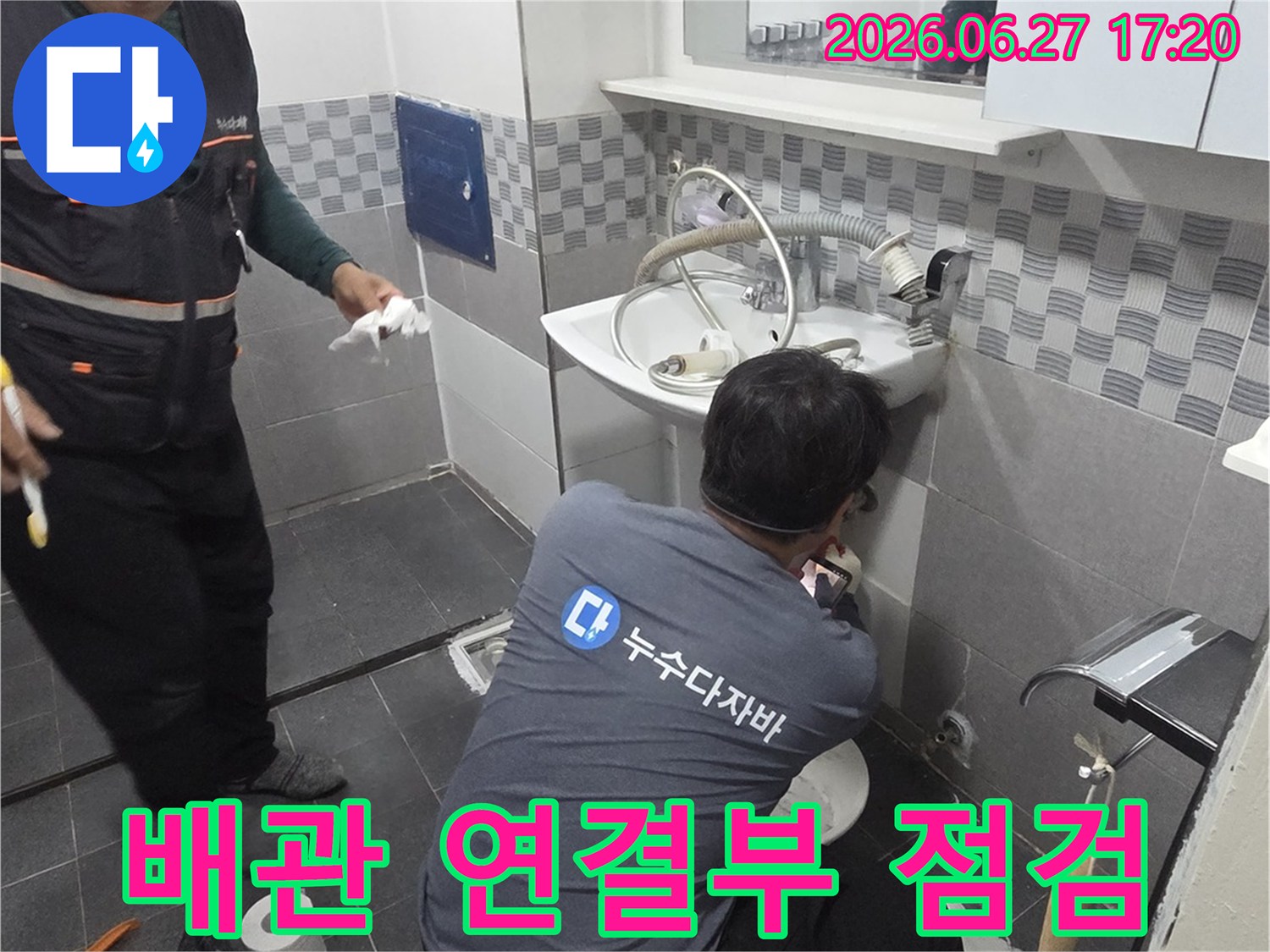 욕실 세면대 아래의-배관 연결 부위에서-누수 발생 가능성을-집중적으로 확인하는 전문가의 모습