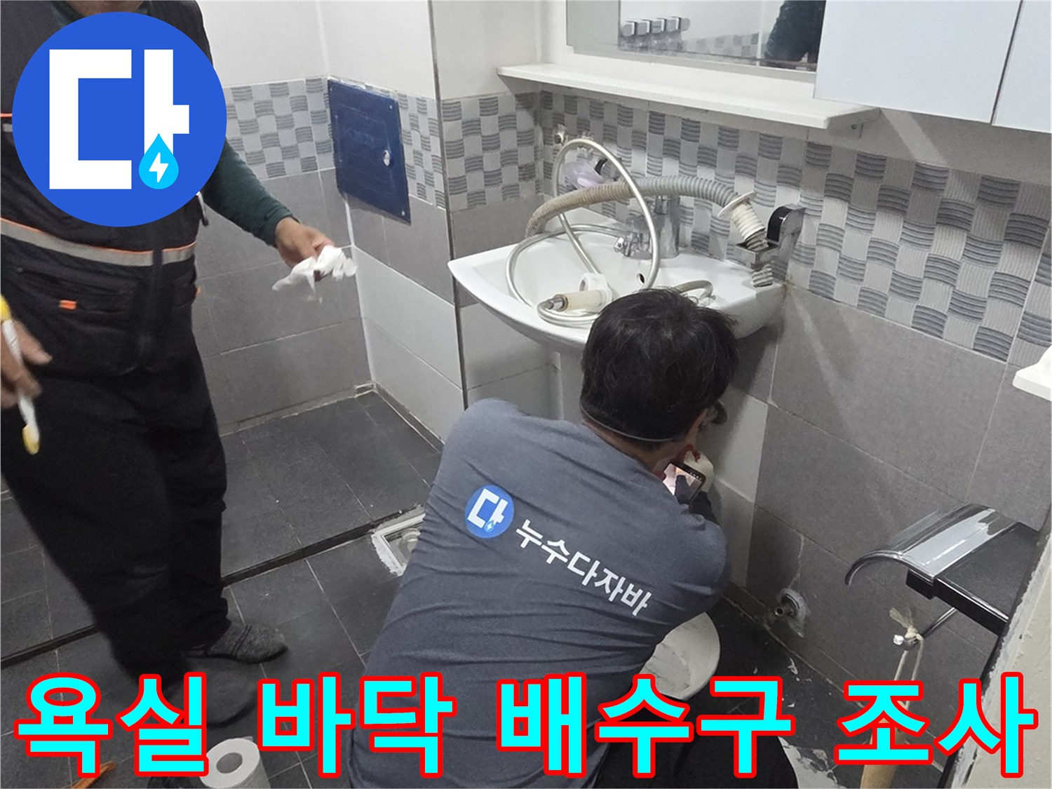 작업자가 엎드려 욕실 유가와 타일 사이의 물샘 경로를 찾는 모습