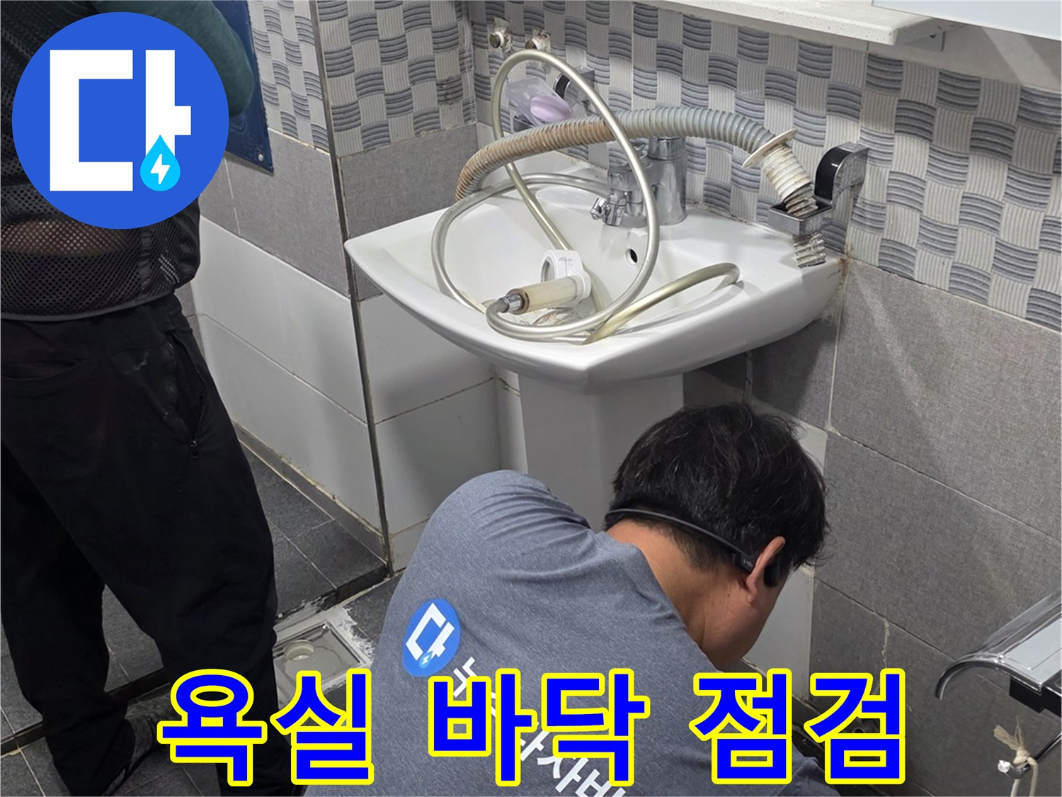 현장 엔지니어가 욕실 배수구 유가 부위의 누수 상태를 면밀하게 조사하는 장면입니다.