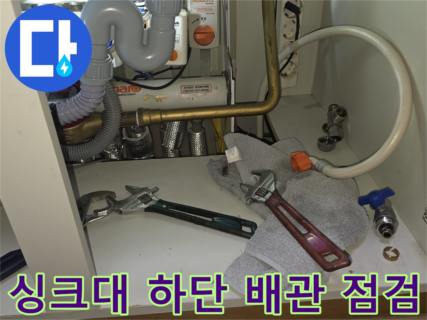 주방 싱크대 하부장 내부의 배관과 공구 상태 - 누수 점검 중