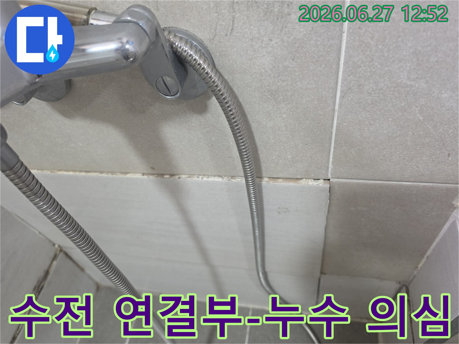 샤워 호스 연결부 주변의 벽 타일과-그 아래 줄눈의 손상 및 변색 모습