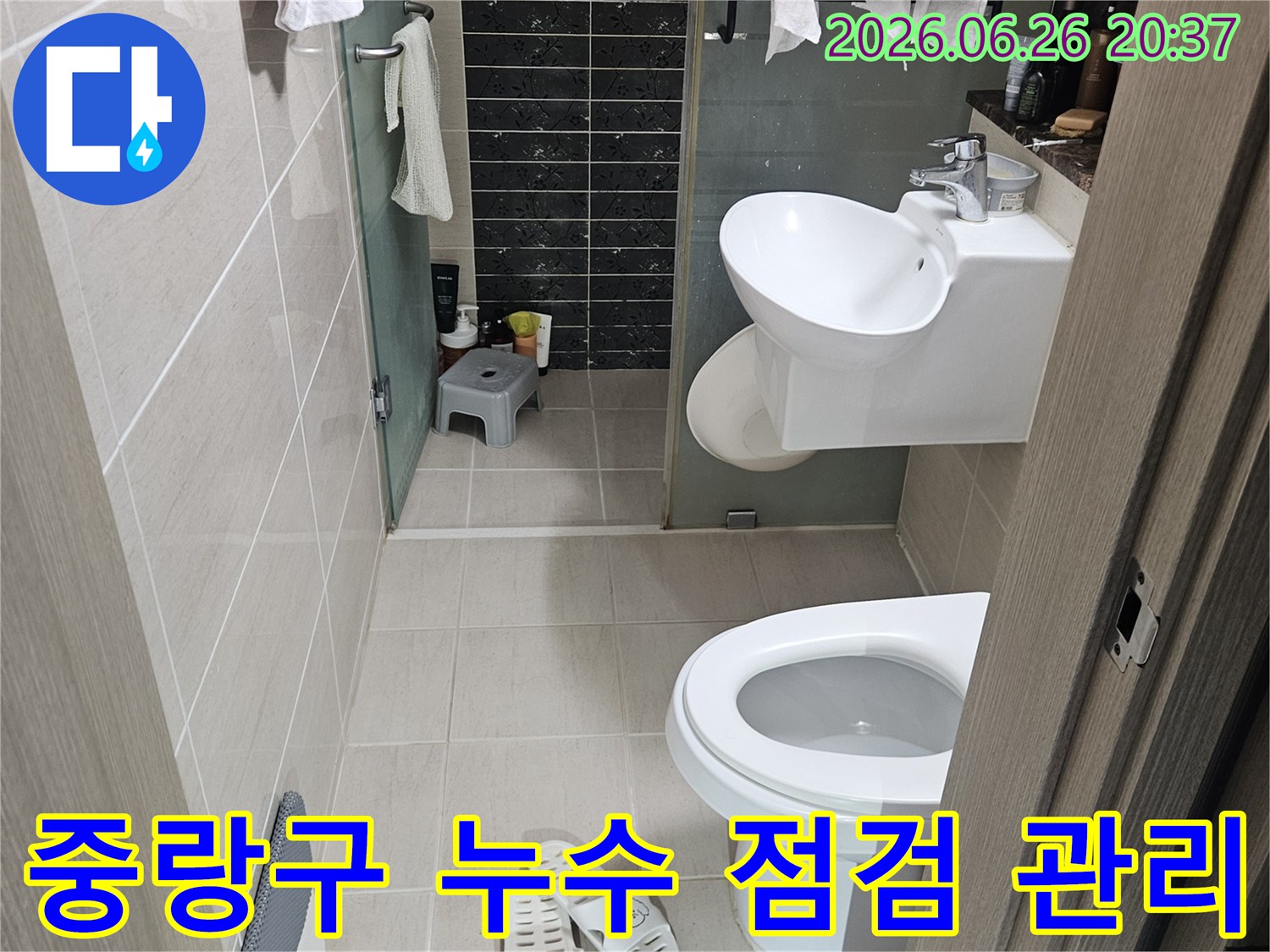 이 이미지는-서울 중랑구의 한 화장실에서-정기적인 누수 점검을-진행하기 전-현장 상황을 보여줍니다-변기와 세면대가 보입니다