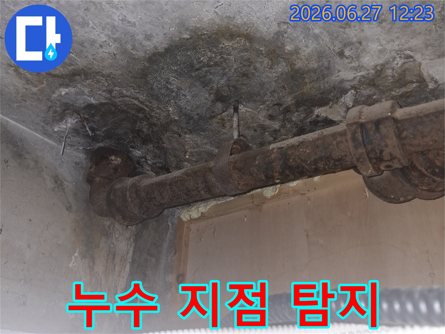 오래된 아파트의-녹슨 배관 주변에서-발견된 누수 흔적을-보여주는-젖은 콘크리트 바닥과-부식된 파이프의-상세 이미지입니다