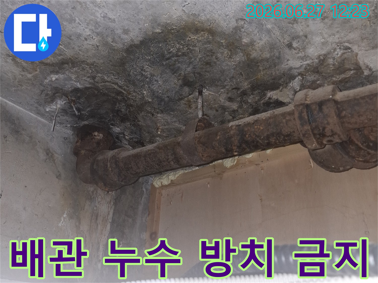 오래된 아파트의-녹슨 배관 주변에서-발견된 누수 흔적을-보여주는-젖은 콘크리트 바닥과-부식된 파이프의-상세 이미지입니다
