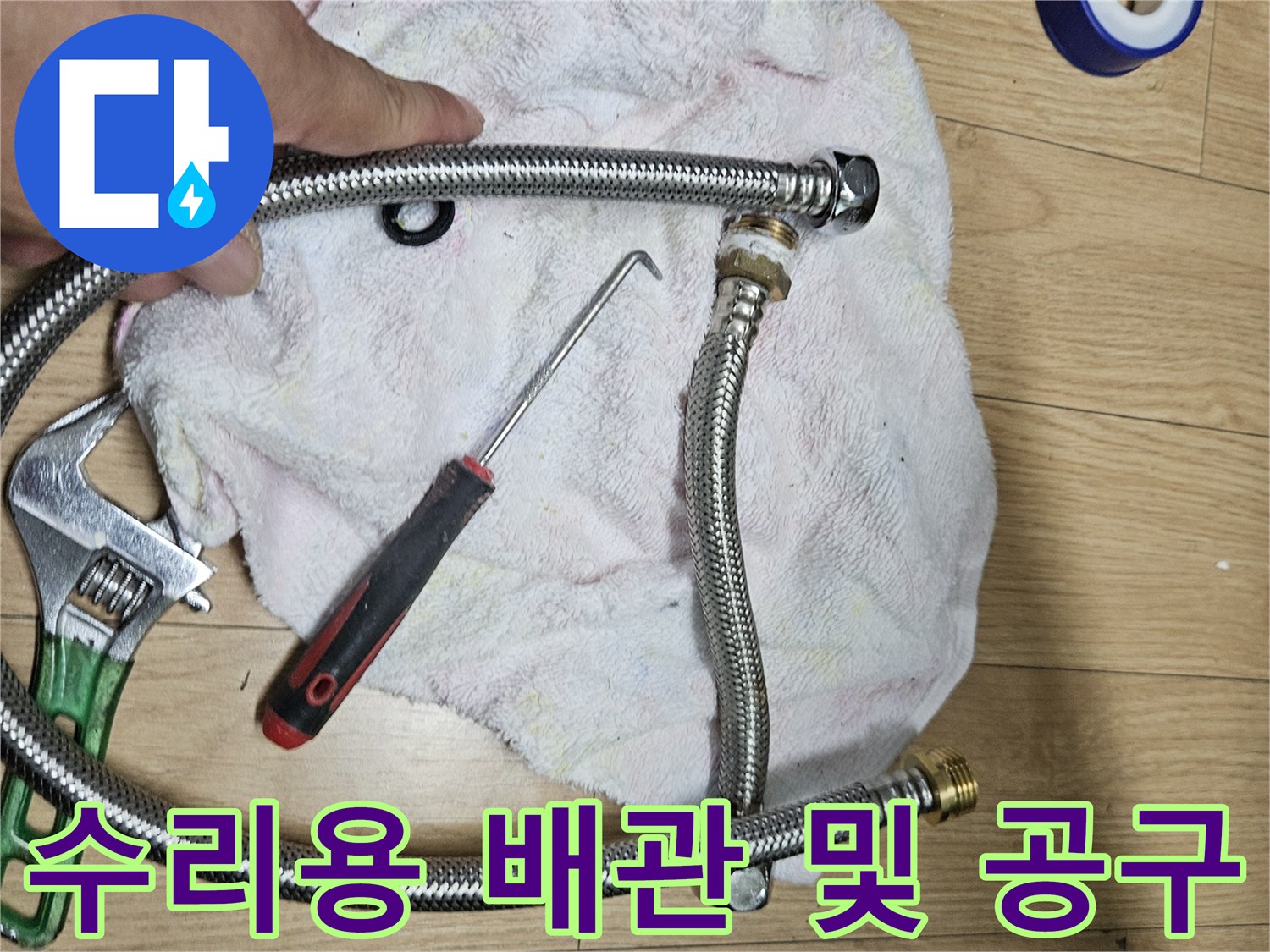 배관 교체 작업에 쓰이는 주름 호스와 몽키스패너와 드라이버